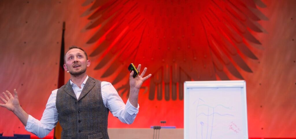 Florian Wildgruber als Speaker bei einem Vortrag auf der Bühne
